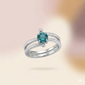  Sterling silver teal stone ring floating view, showing double band and prong-set round gemstone from front angle