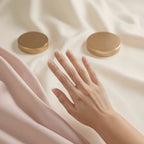Woman's hand wearing sheer nude press on nails with glossy clear tip, close-up on fingertips