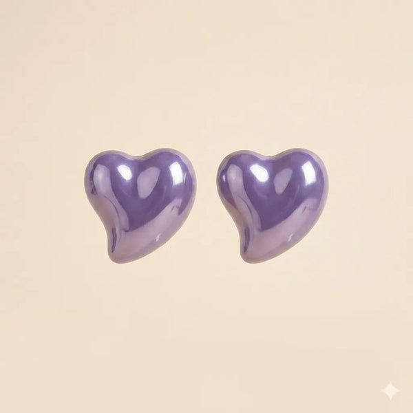 Pair of glossy purple puffy heart stud earrings with high-shine lacquer finish on beige background