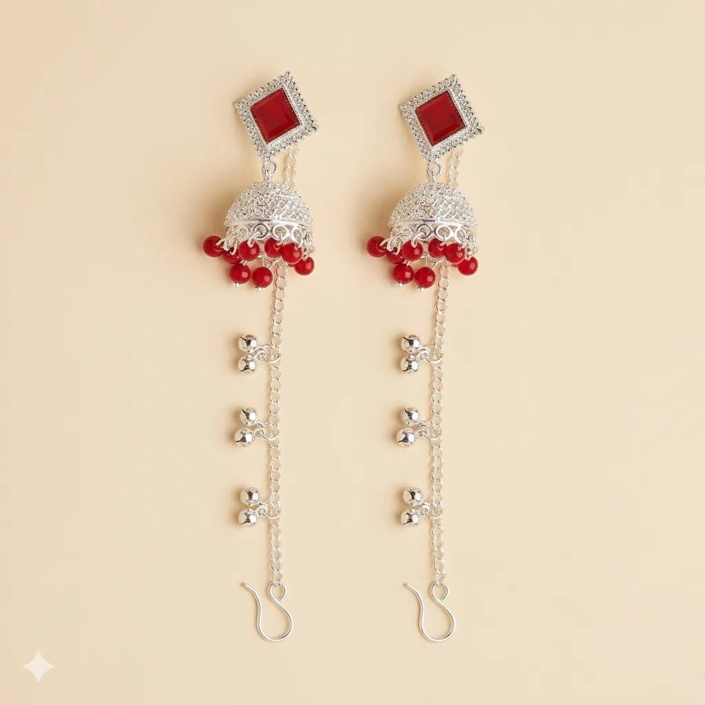 Silver red mirror stone jhumka earrings with long ghungroo kan chain and hook on beige background