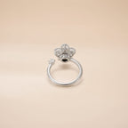 Silver flower cluster ring with round CZ petals and open band on satin background