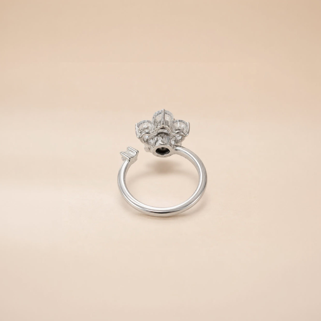 Silver flower cluster ring with round CZ petals and open band on satin background