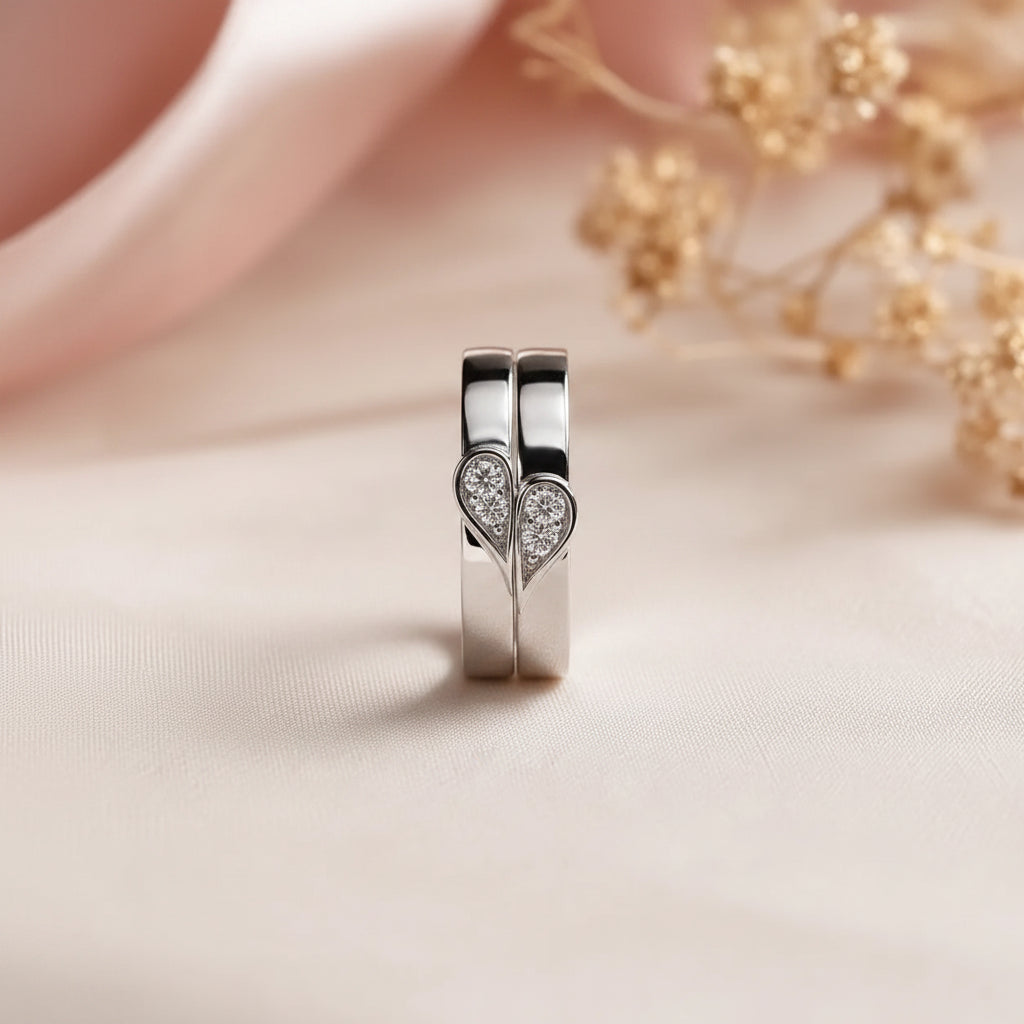 Close-up of hand wearing stacked his and hers heart rings forming a complete heart shape