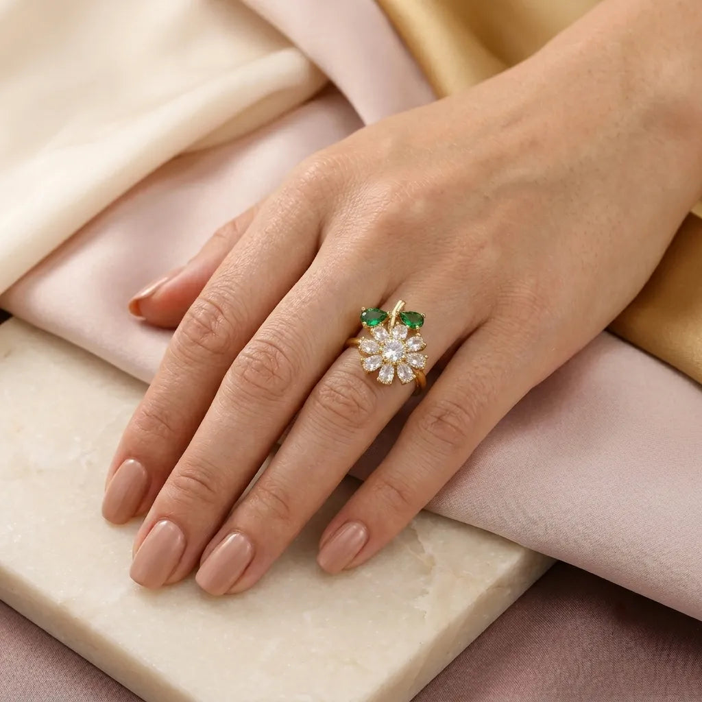 "Close-up of CZ daisy ring with emerald leaves worn on hand"