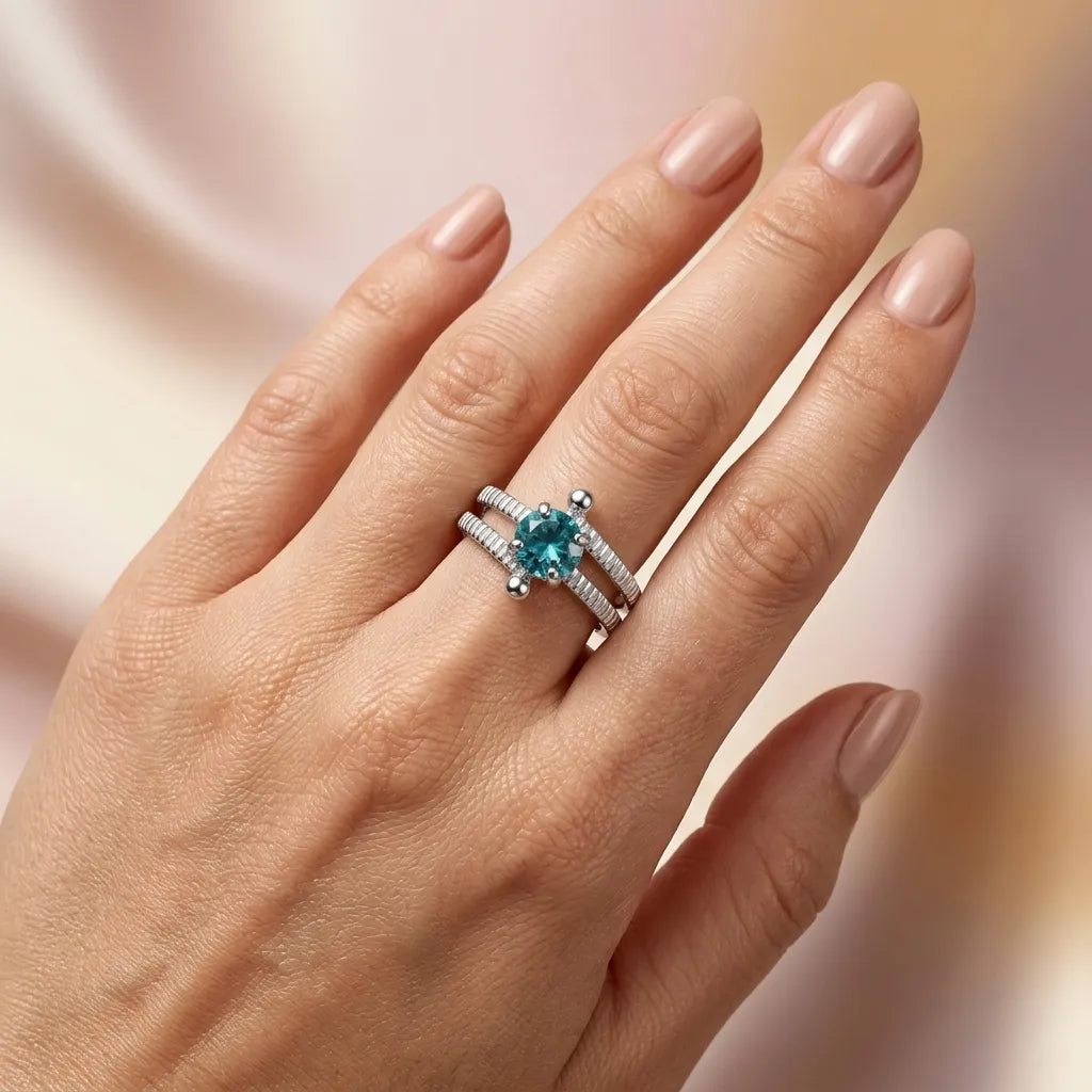 Woman wearing teal gemstone sterling silver ring on ring finger, split band design with textured detail