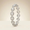Two silver emerald cut cubic zirconia halo bangle bracelets overlapping on beige background showing octagonal link detail and brilliant crystal clarity