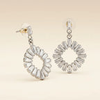 Silver rhodium-plated baguette cubic zirconia open wreath circle drop earrings on beige background
