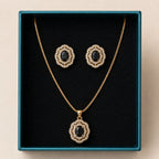 Black onyx gold jewelry set with pendant necklace and matching earrings displayed in teal gift box