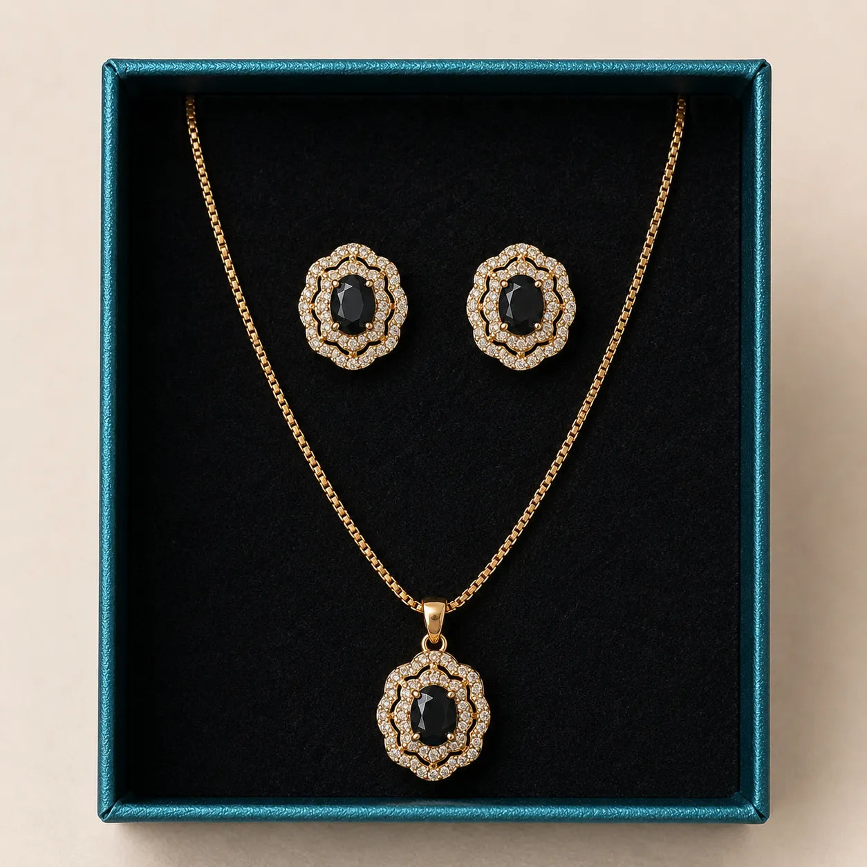 Black onyx gold jewelry set with pendant necklace and matching earrings displayed in teal gift box