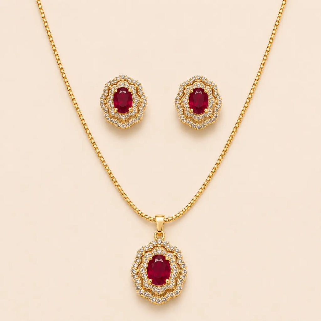Gold ruby halo necklace and matching stud earrings laid flat on beige background