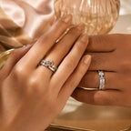 Couple wearing silver crown tiara heart ring (her) and wide CZ band ring (his) — matching couple ring set on both hands