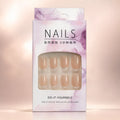Eight sheer nude press on nails with glossy clear tips laid flat on beige background