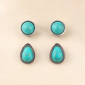 Flat lay of two turquoise earring pairs, round and teardrop shapes, antique silver trim