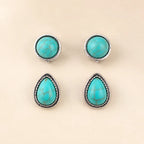 Flat lay of two turquoise earring pairs, round and teardrop shapes, antique silver trim