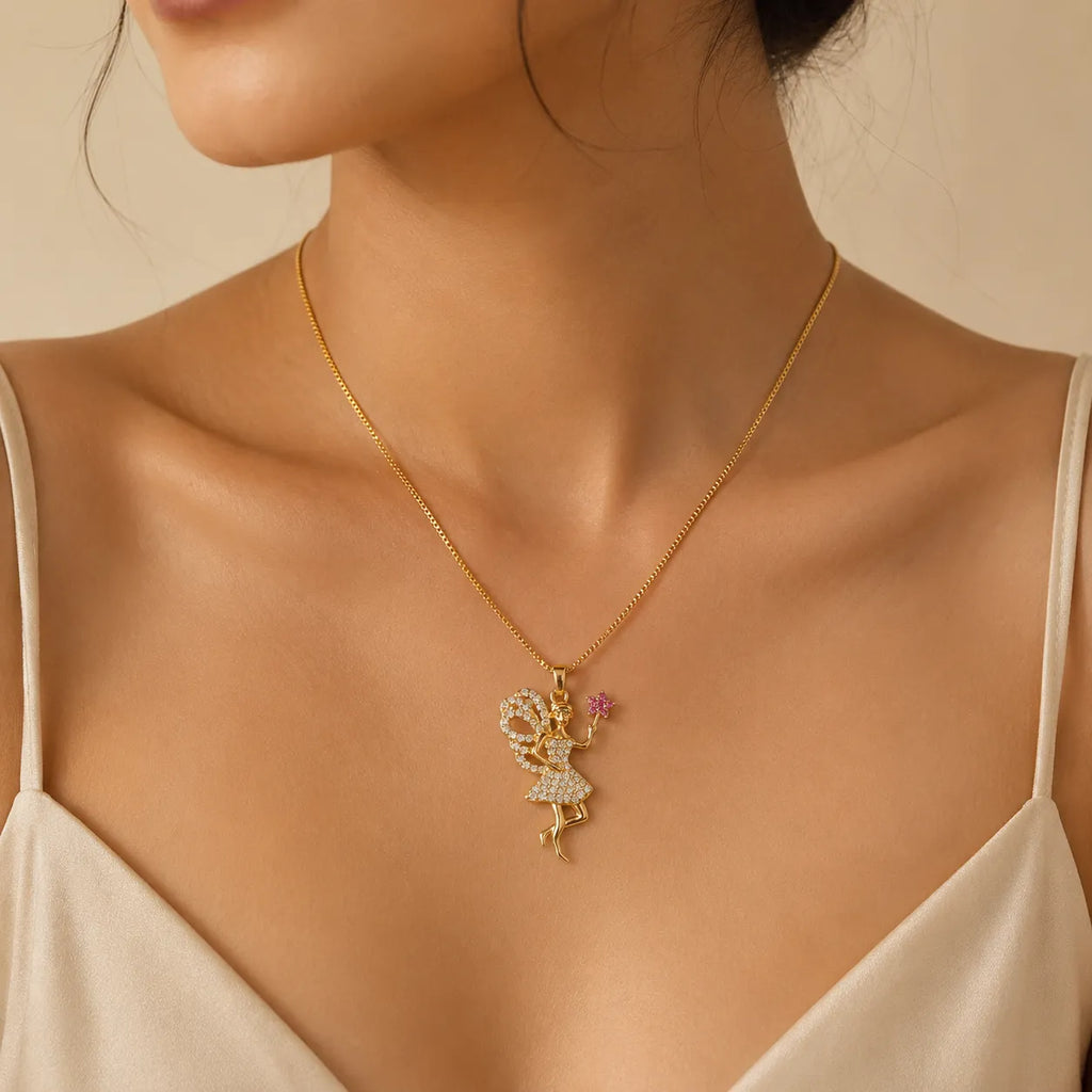 Woman wearing gold fairy pendant necklace with crystal detailing and pink flower charm, close-up necklace photo