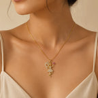 Woman wearing gold fairy pendant necklace with crystal detailing and pink flower charm, close-up necklace photo