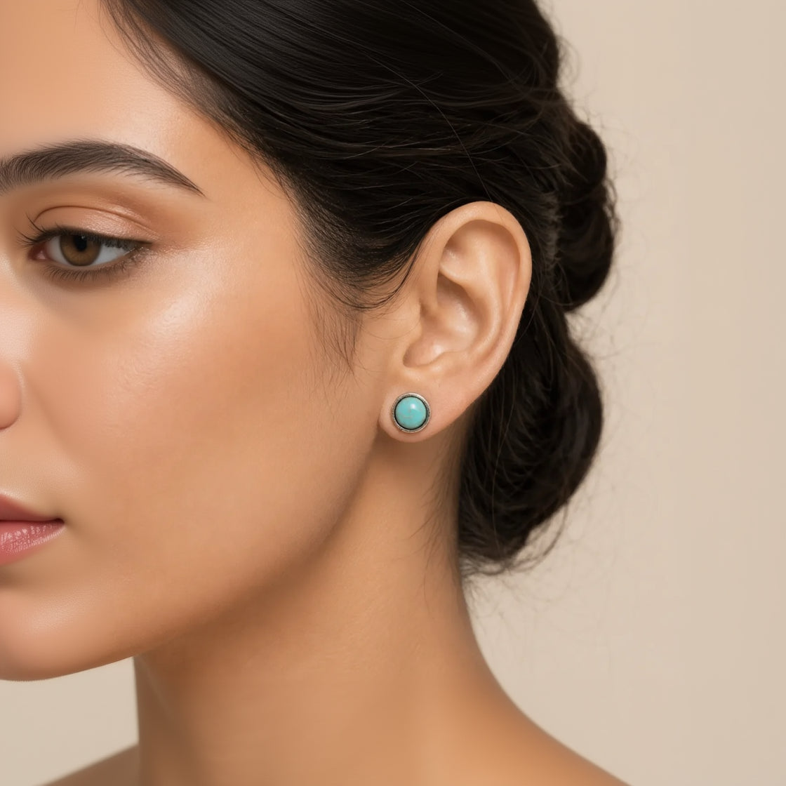 Close-up of model wearing round turquoise stud earring in antique silver setting