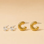  "Set of gold chunky hoop earrings and CZ stud earrings on beige background"