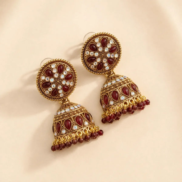 Antique gold maroon kundan dome jhumka earrings showing iridescent crystal floral disc stud and textured dome bell with bead fringe
