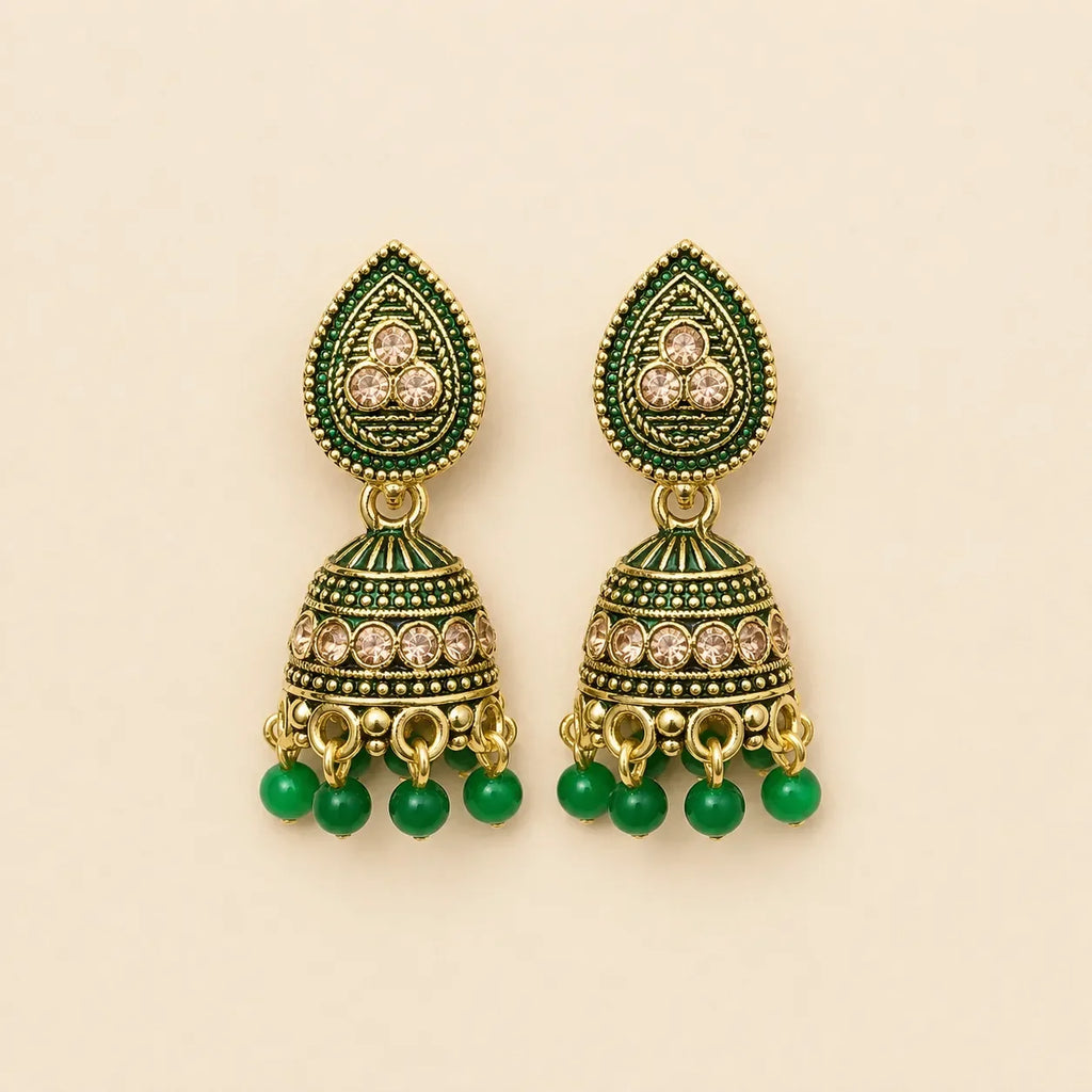 Pair of antique gold emerald green meenakari teardrop stud dome jhumka earrings with champagne crystal band and green bead drops on cream background
