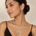 Model wearing blue crystal teardrop necklace and matching dangle earrings with black dress