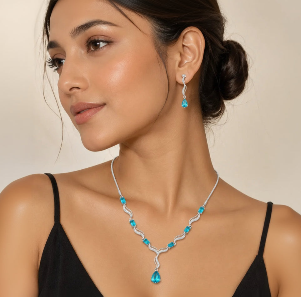 Model wearing blue crystal teardrop necklace and matching dangle earrings with black dress