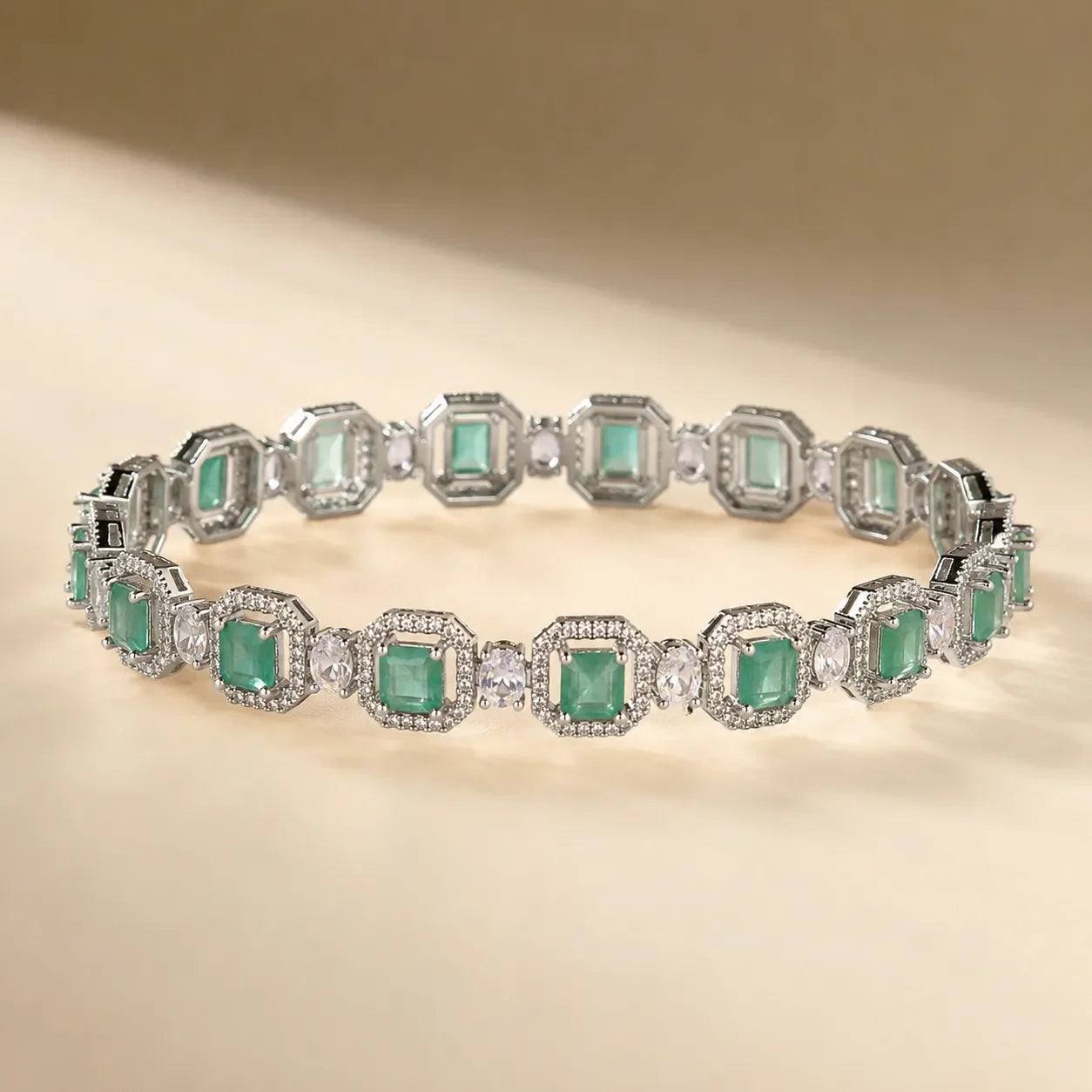 Silver mint seafoam green emerald cut octagonal halo CZ bangle bracelet showing continuous link design and crystal detail on beige