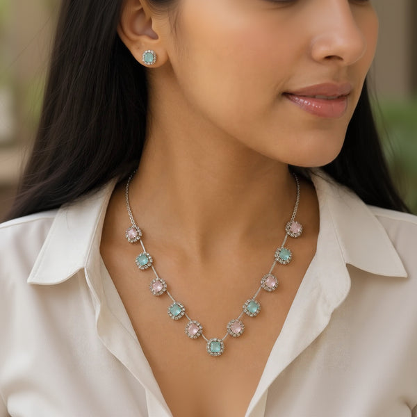  Woman wearing pink and mint crystal halo necklace and matching stud earring, close-up on neckline and ear