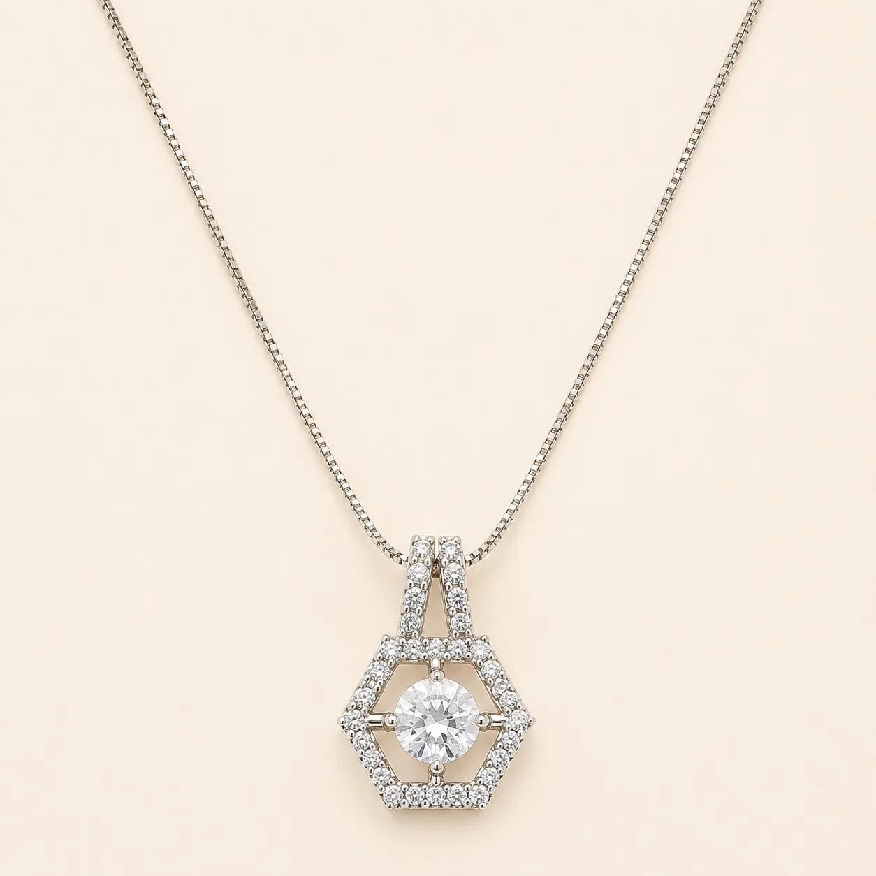 Silver hexagon halo necklace with round cut CZ center stone and double-bail chain detail on beige background