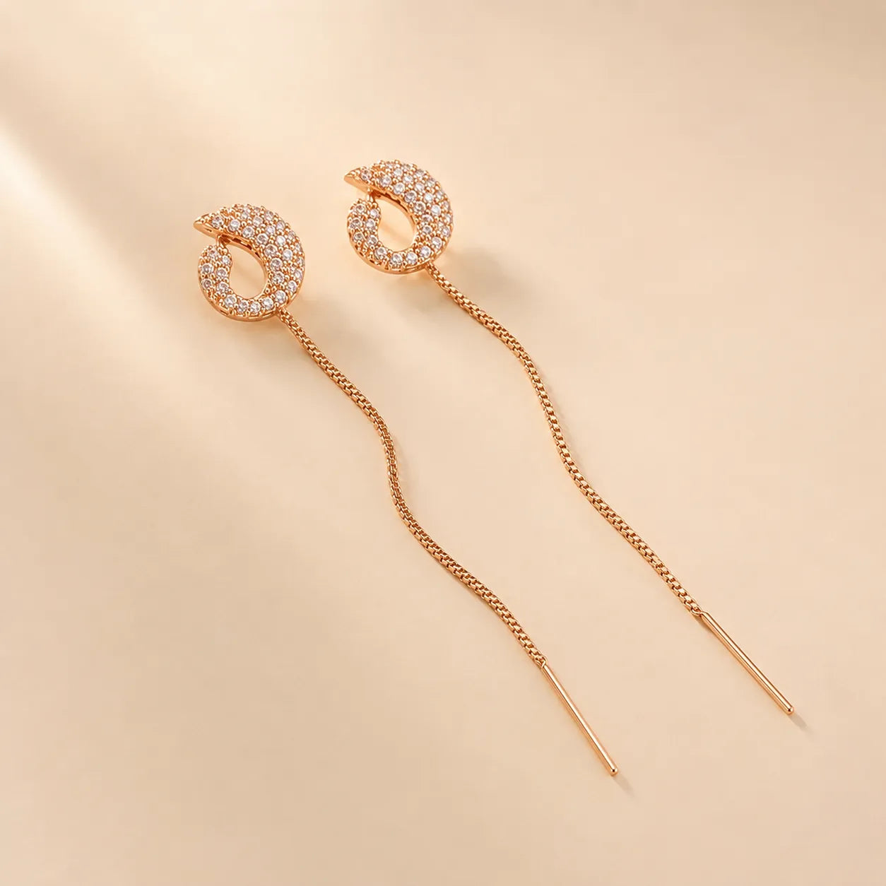 "Rose gold pave crystal earrings with chain threader detail"