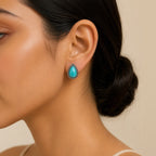 Close-up of model wearing teardrop turquoise stud earring in antique silver setting