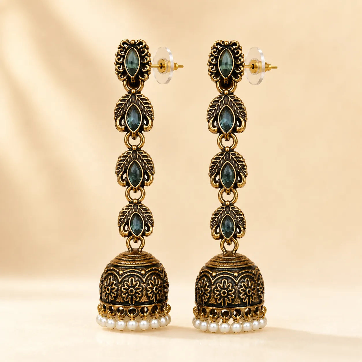 Antique gold jhumka earrings with blue crystal stones and pearl drops, traditional Indian dangle earrings on gold background