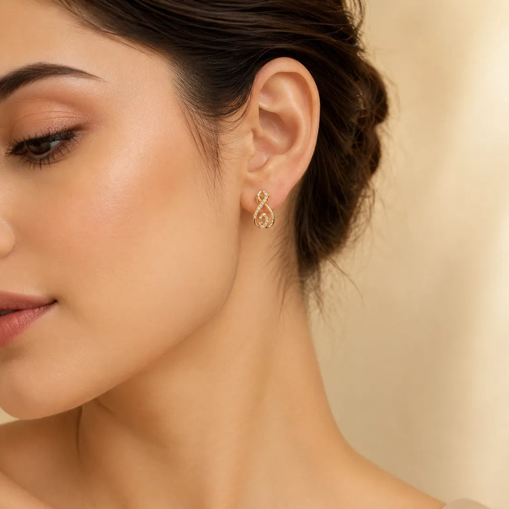 "Woman wearing gold CZ infinity swirl stud earring"