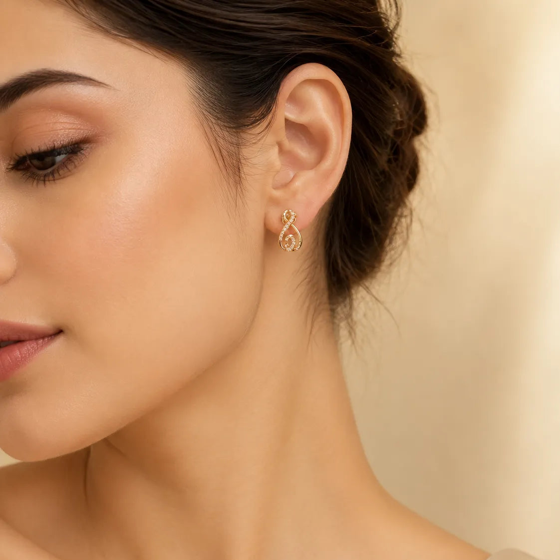 "Woman wearing gold CZ infinity swirl stud earring"