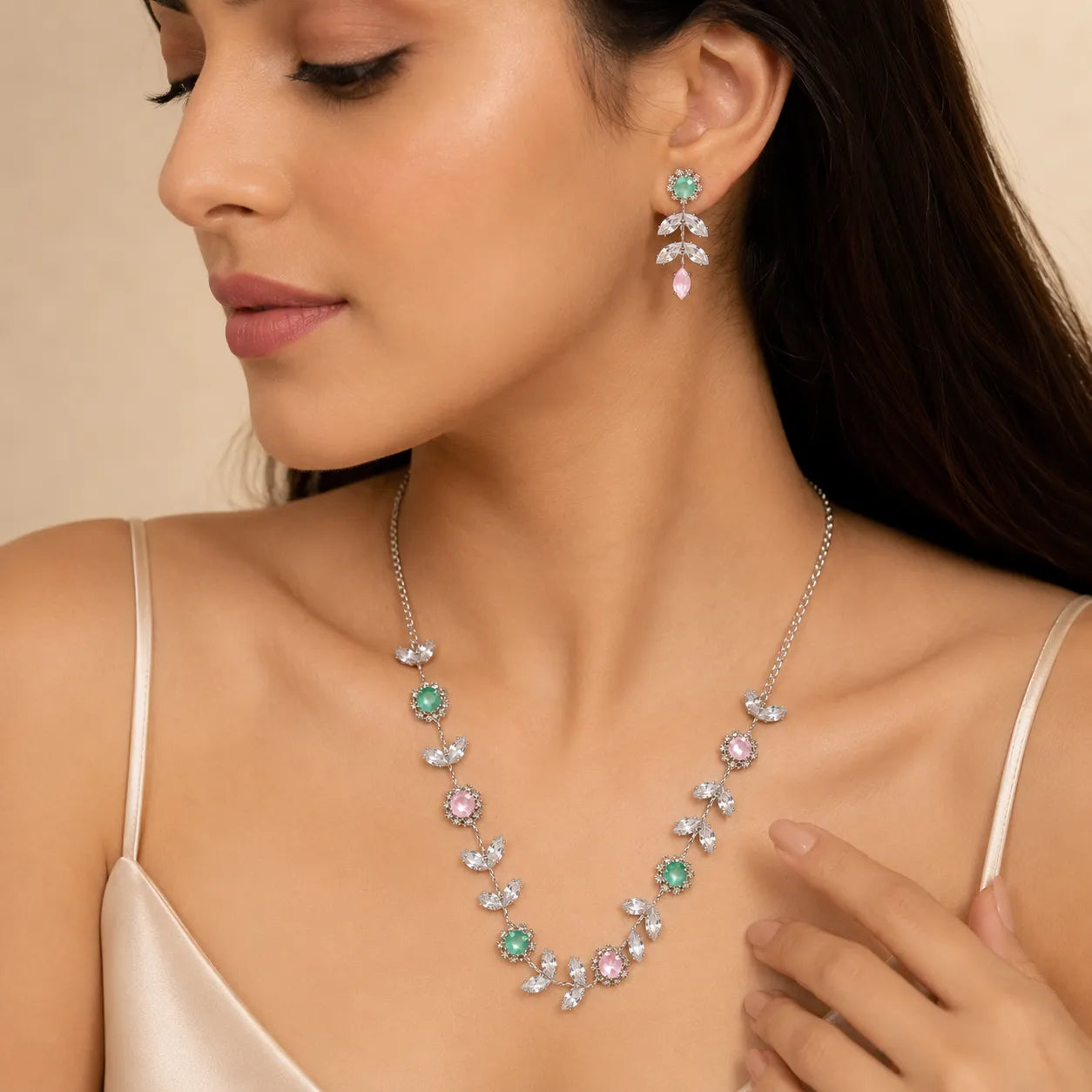 Woman wearing silver crystal vine necklace and floral drop earrings, close-up on neckline and ear