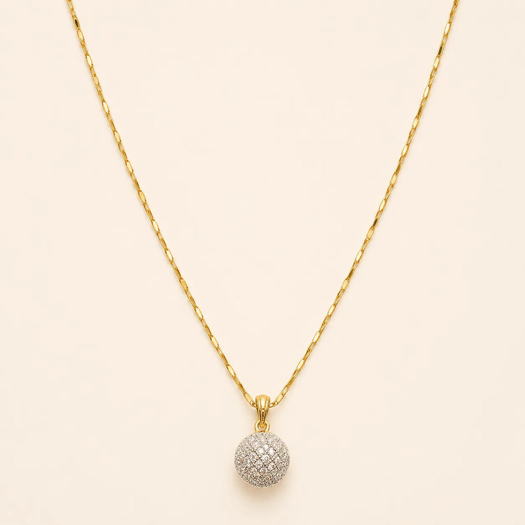 Close-up of gold necklace chain and sparkly pavé crystal ball pendant with lobster clasp detail