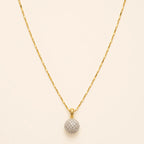 Close-up of gold necklace chain and sparkly pavé crystal ball pendant with lobster clasp detail