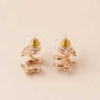 A pair of gold and rose gold spiral stud earrings with clear crystal accents, 