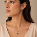 Woman wearing gold plated black onyx pendant necklace and matching stud earrings, close-up on neckline and ear