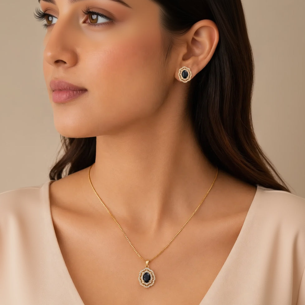 Woman wearing gold plated black onyx pendant necklace and matching stud earrings, close-up on neckline and ear