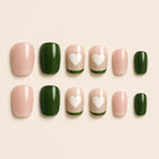 "Set of pink and green press-on nails with white heart French tip design"