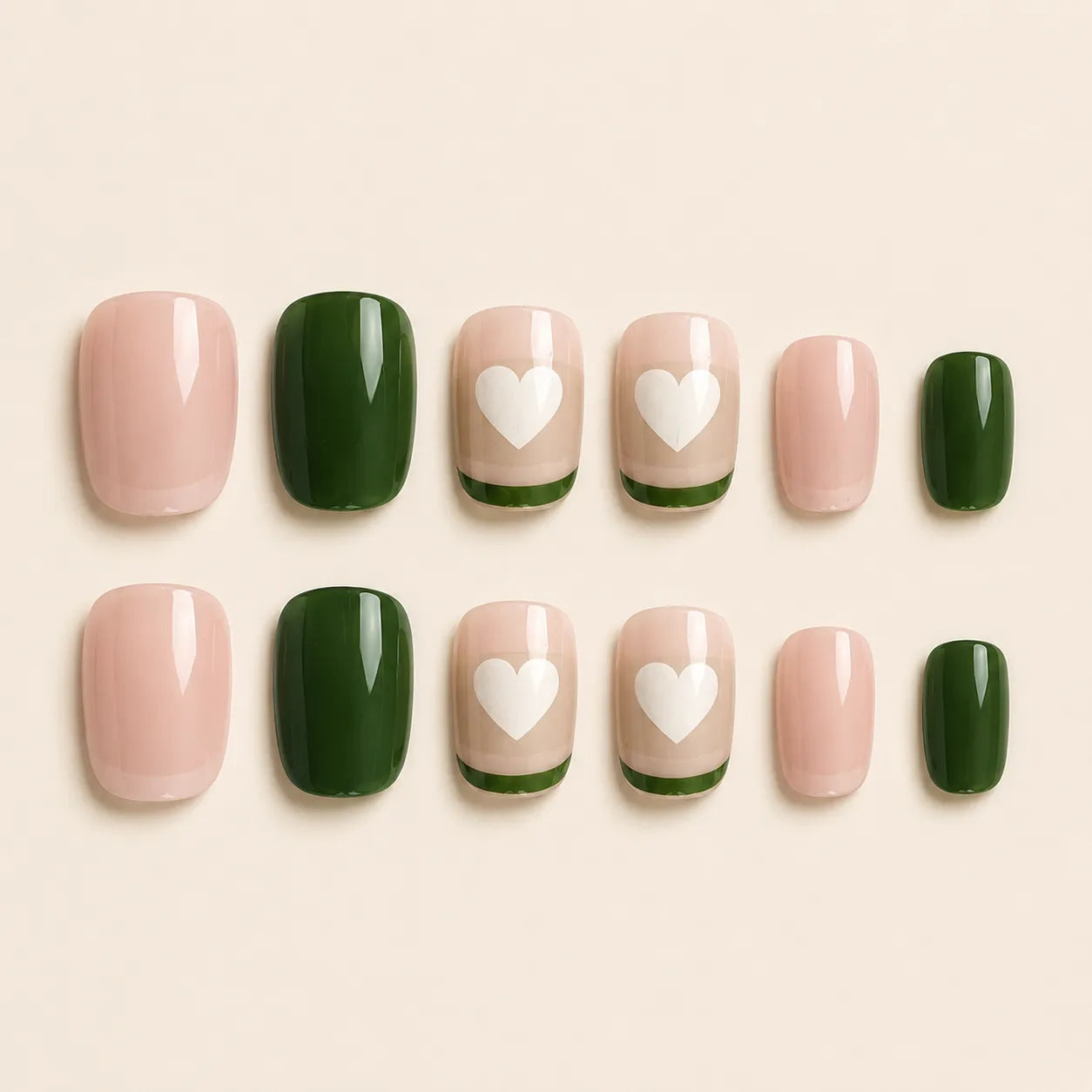 "Set of pink and green press-on nails with white heart French tip design"