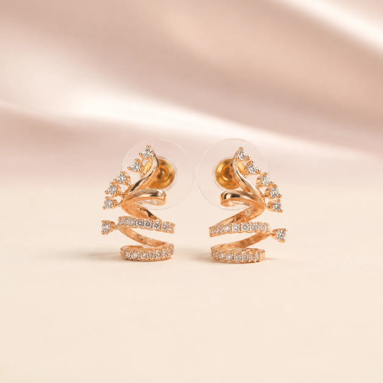 Back view of rose gold sculptural spiral coil CZ crystal stud earrings showing secure gold pin stud and silicone comfort disc backing