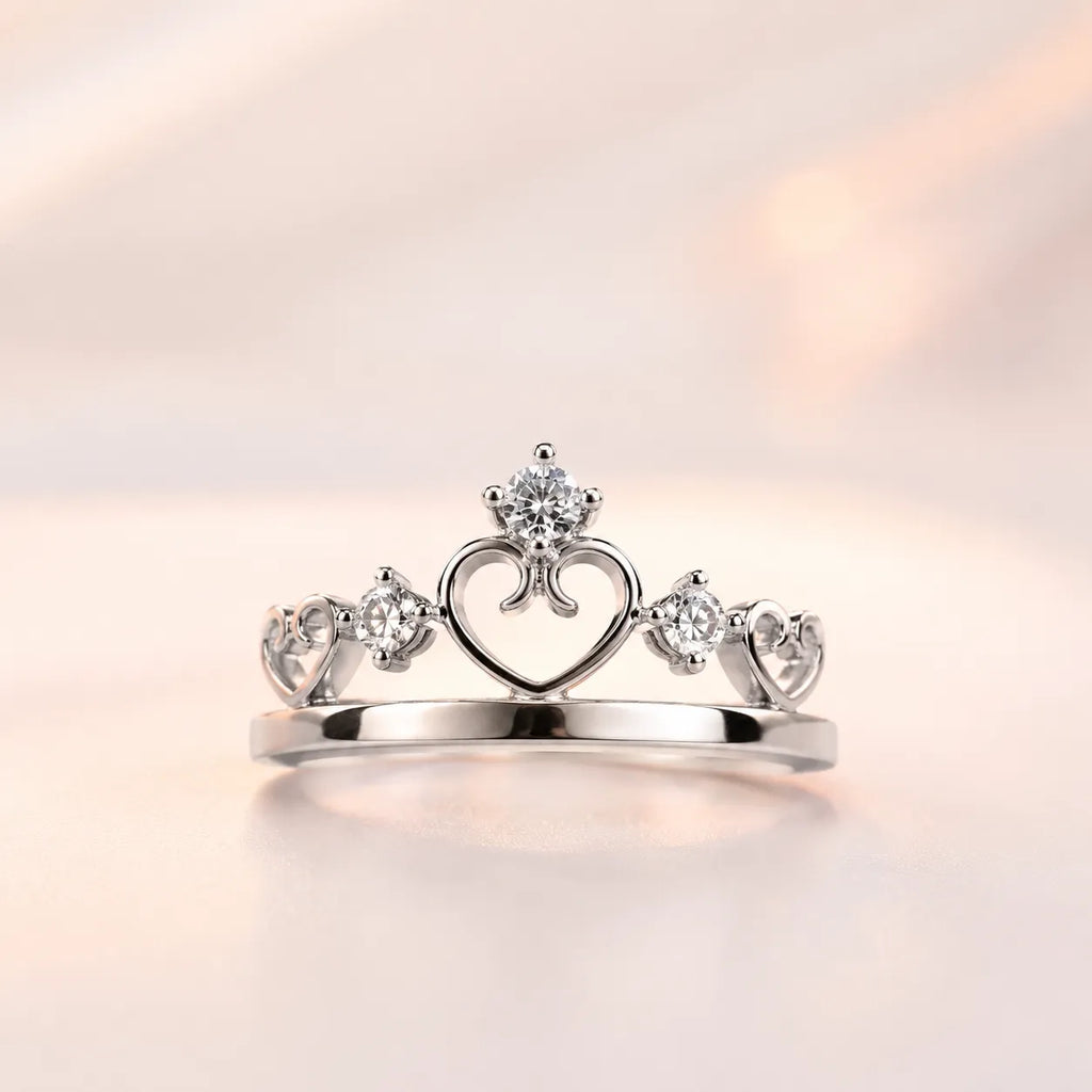 Silver princess crown tiara ring with open heart motif and CZ solitaire — her ring from couple matching set on blush background
