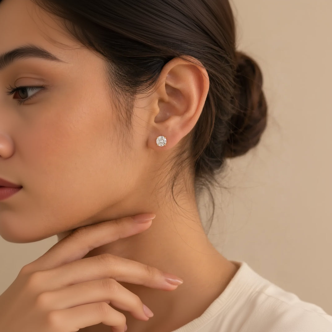 "Woman wearing round CZ stud earring with gold prong setting"