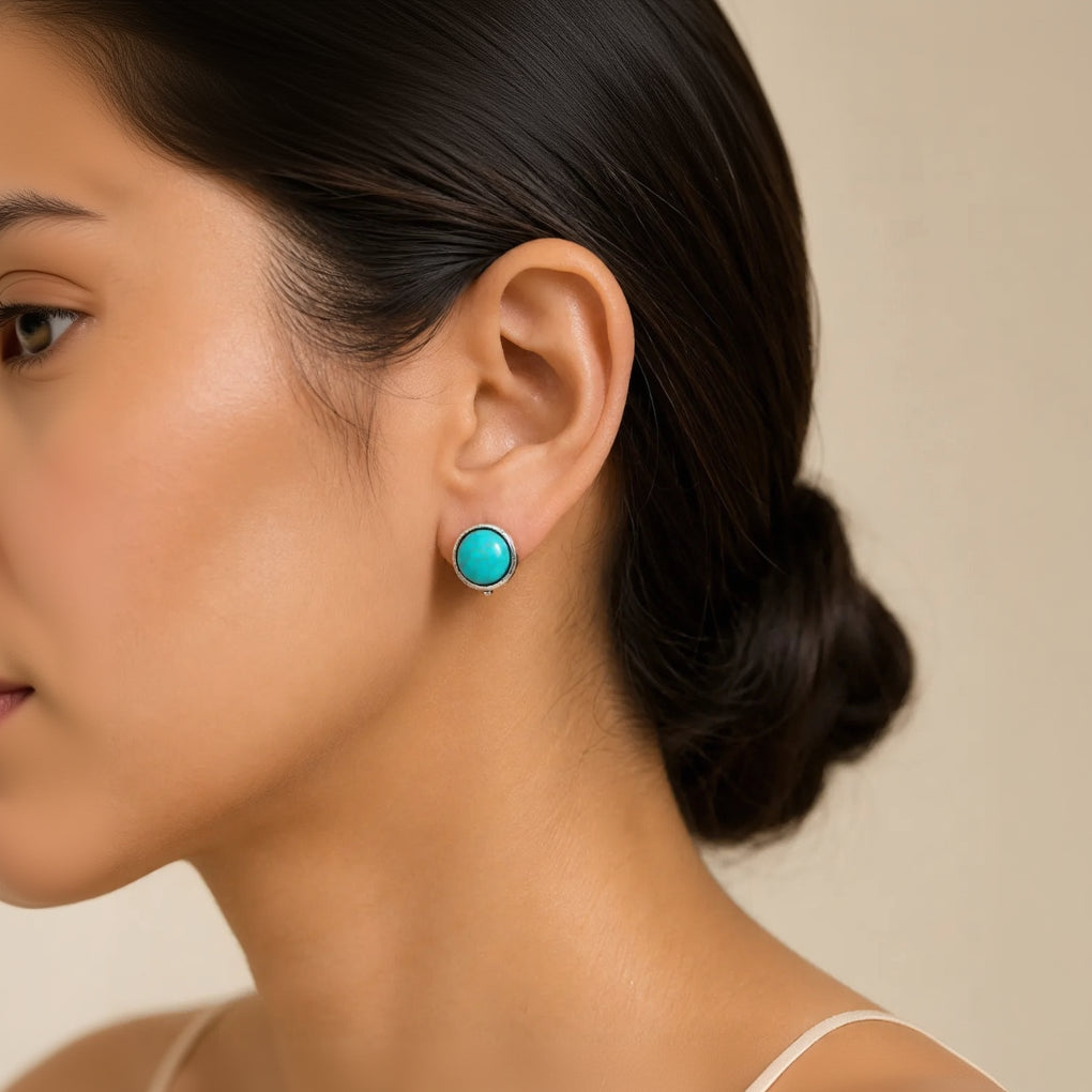 "Woman wearing round turquoise stud earring with silver bezel"