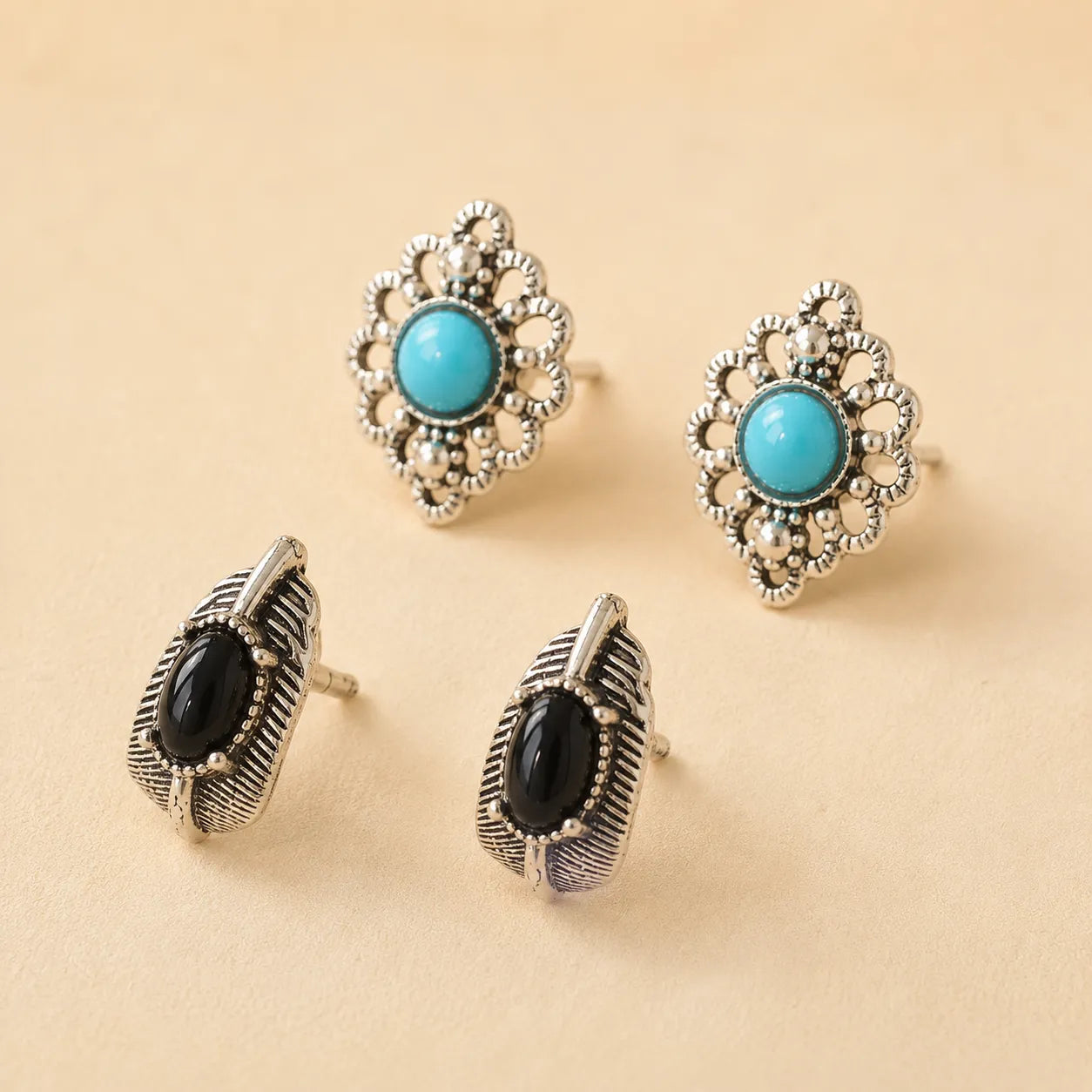 "Set of two stud earrings, turquoise flower design and black onyx leaf design"