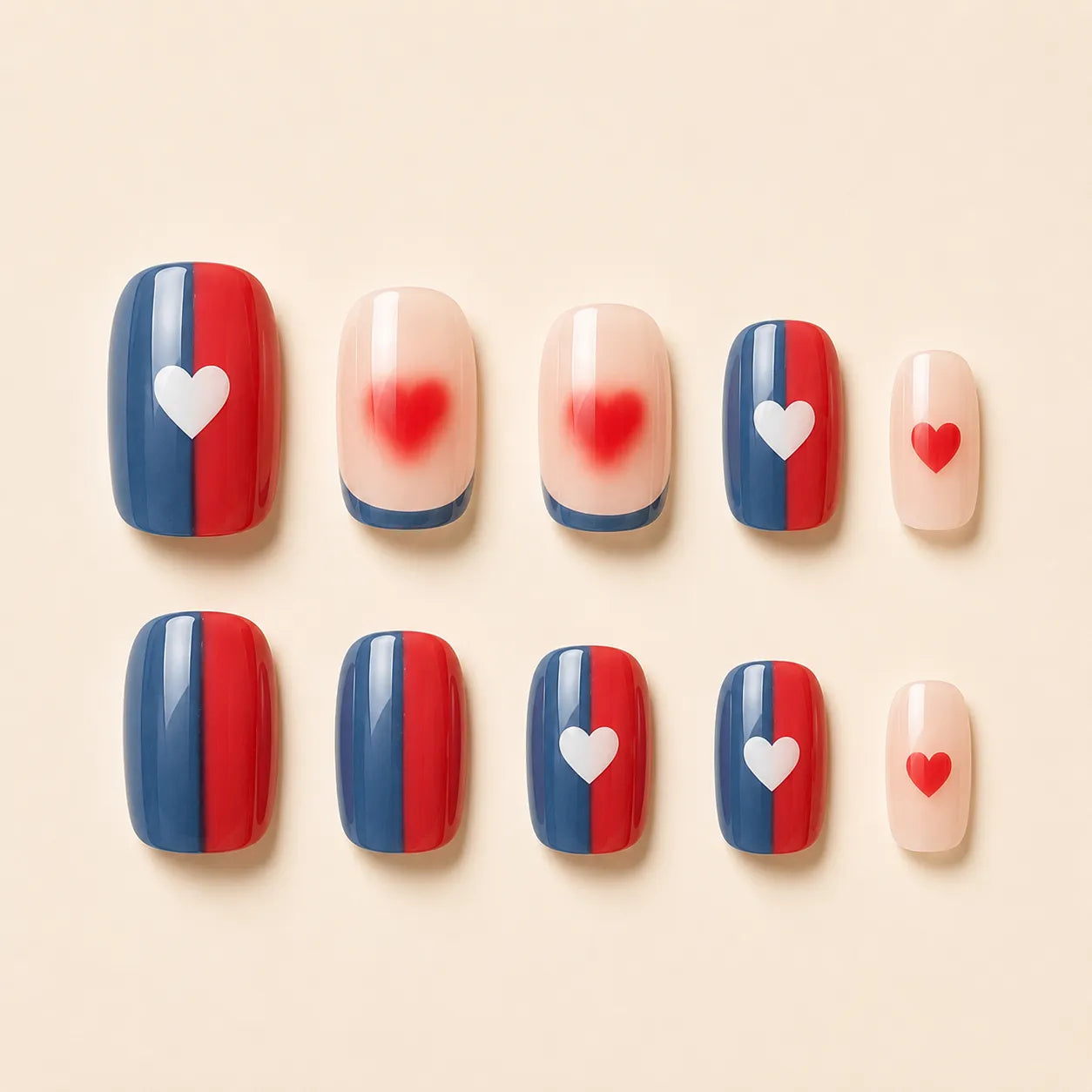 Set of 12 short square red blue color block press-on nails with white heart and aura blur red heart accent nails arranged on cream background