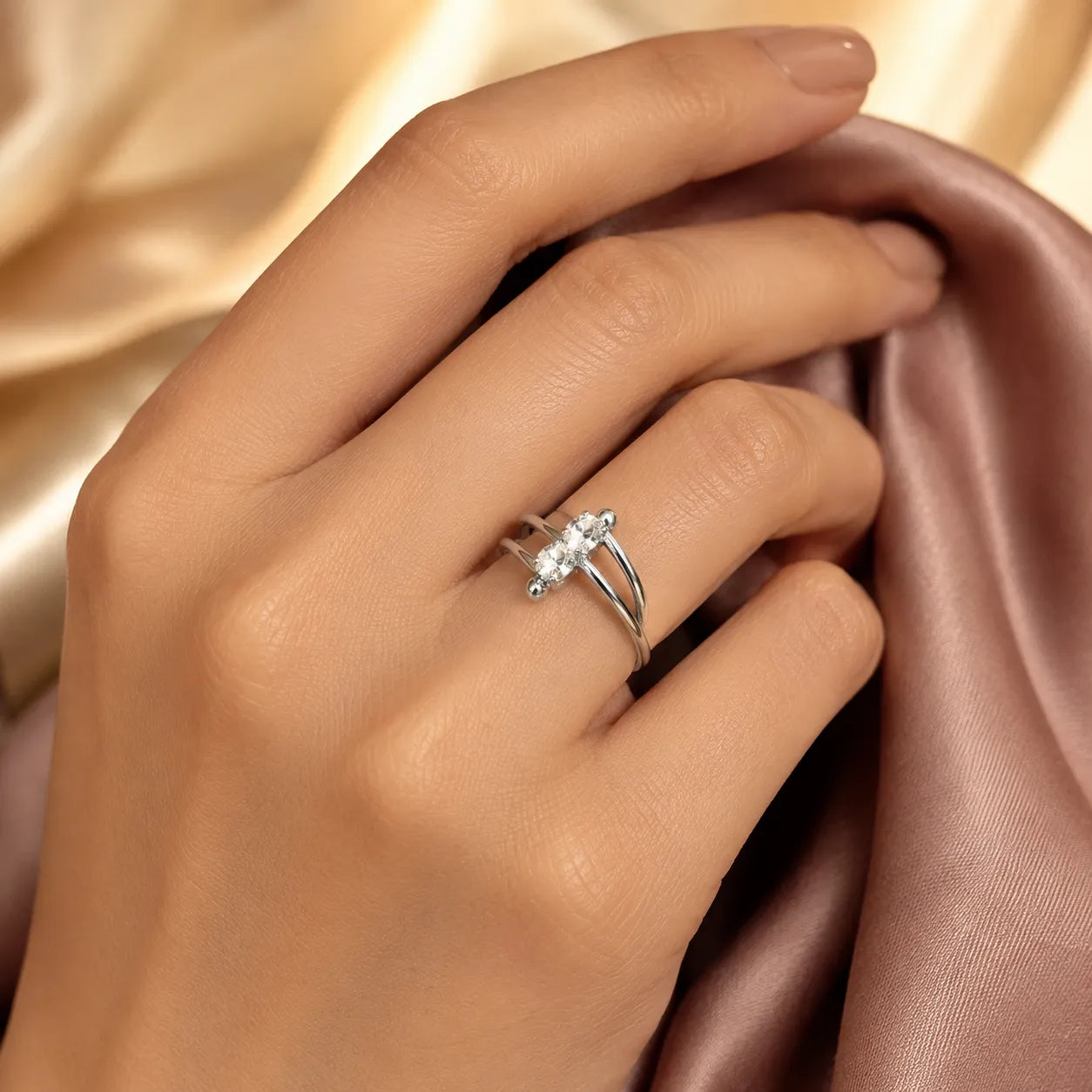 Model wearing silver double-band two stone crossover ring on hand
