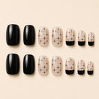 Set of black glossy and nude starburst print press-on nails in assorted sizes